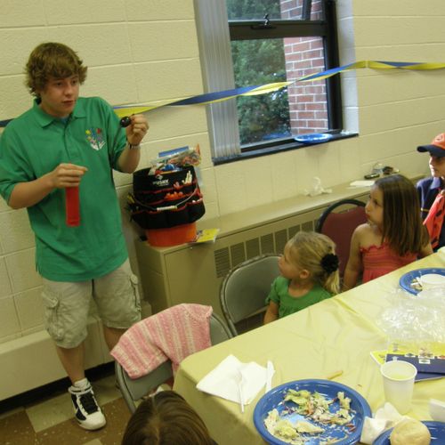 Balloon Artist Blake entertaining a table of Cub S