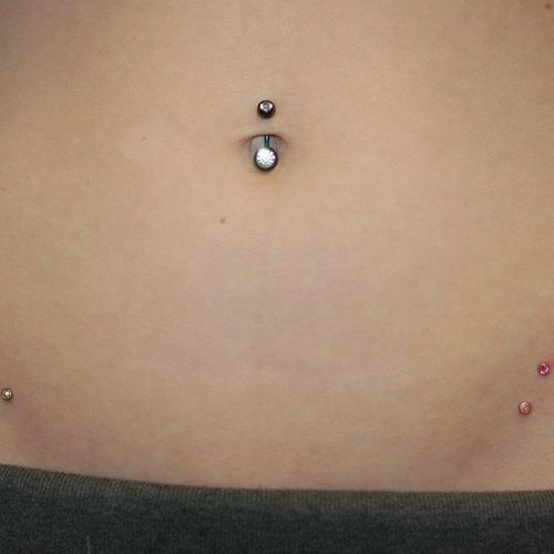 A navel piercing and triple micro-dermals/surface 