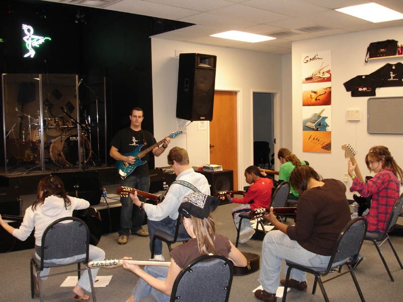 A beginner group guitar class being taught by Paul