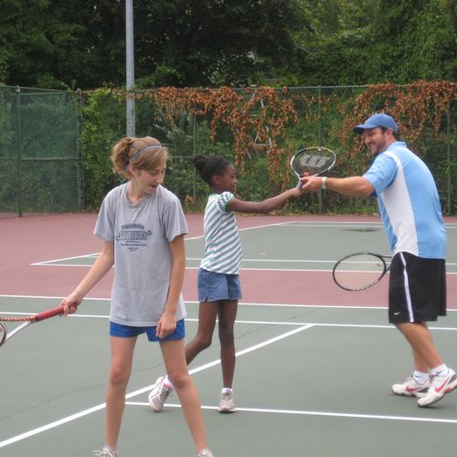 Owner teaching tennis.
