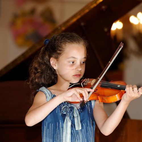 Child violin student at a our school performance