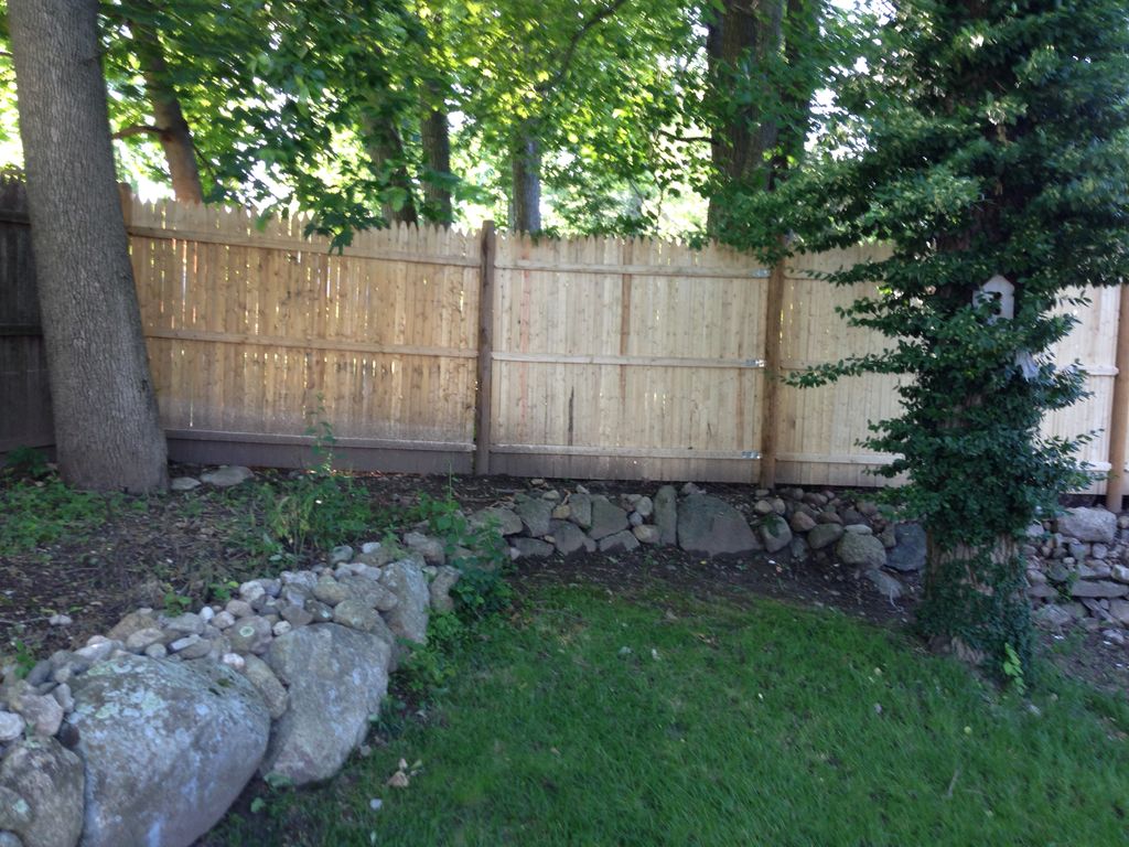 Stockade fence install on top of an existing retai
