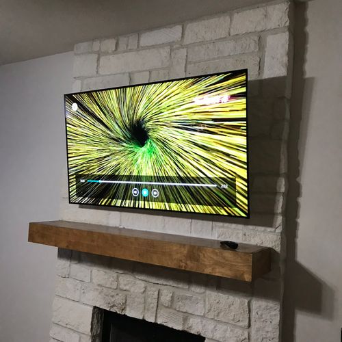 75” with hidden wires over stone fireplace 