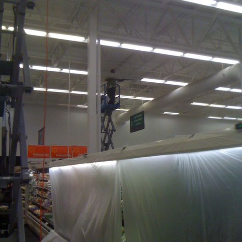 Cleaning bar joists within Wal-mart.