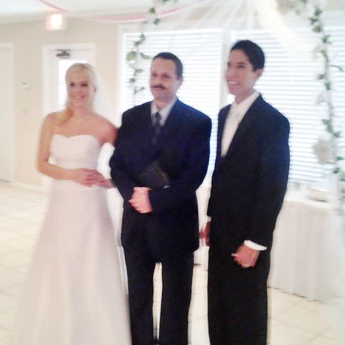 Rev. Tom in the middle of the couple. Just married