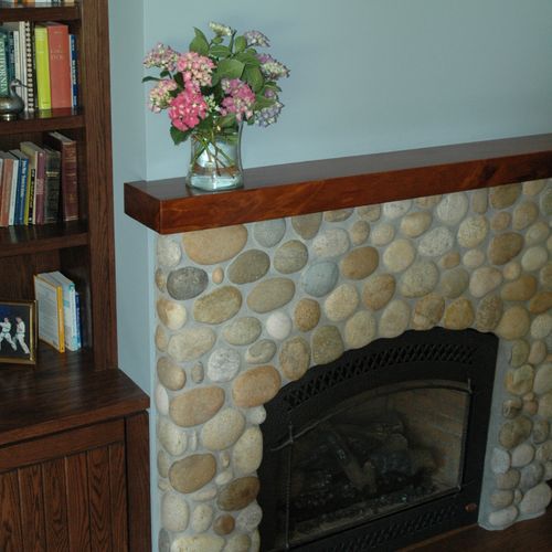Custom river rock fireplace adds charm to this mas