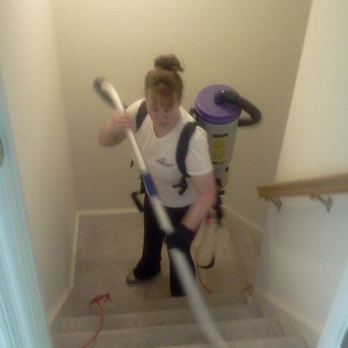 An employee vacuuming stairs with our powerful com