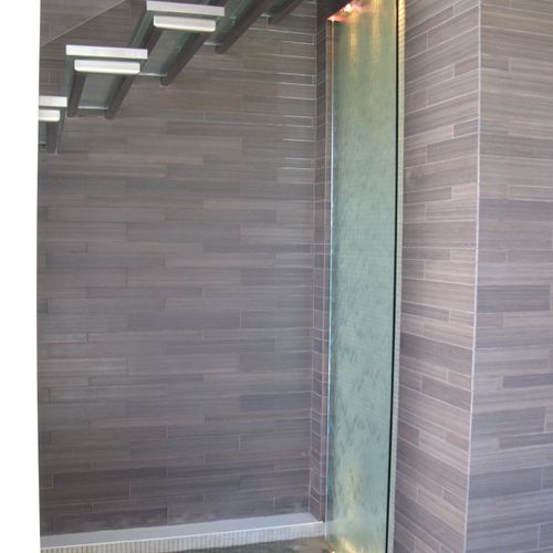 A 30" x 96" glass water wall and pond beneath glas