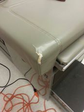 A before picture of a rip in a vinyl exam table at