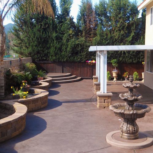 Colored concrete and curvilinear planter walls help make this smaller yard seem much bigger.
