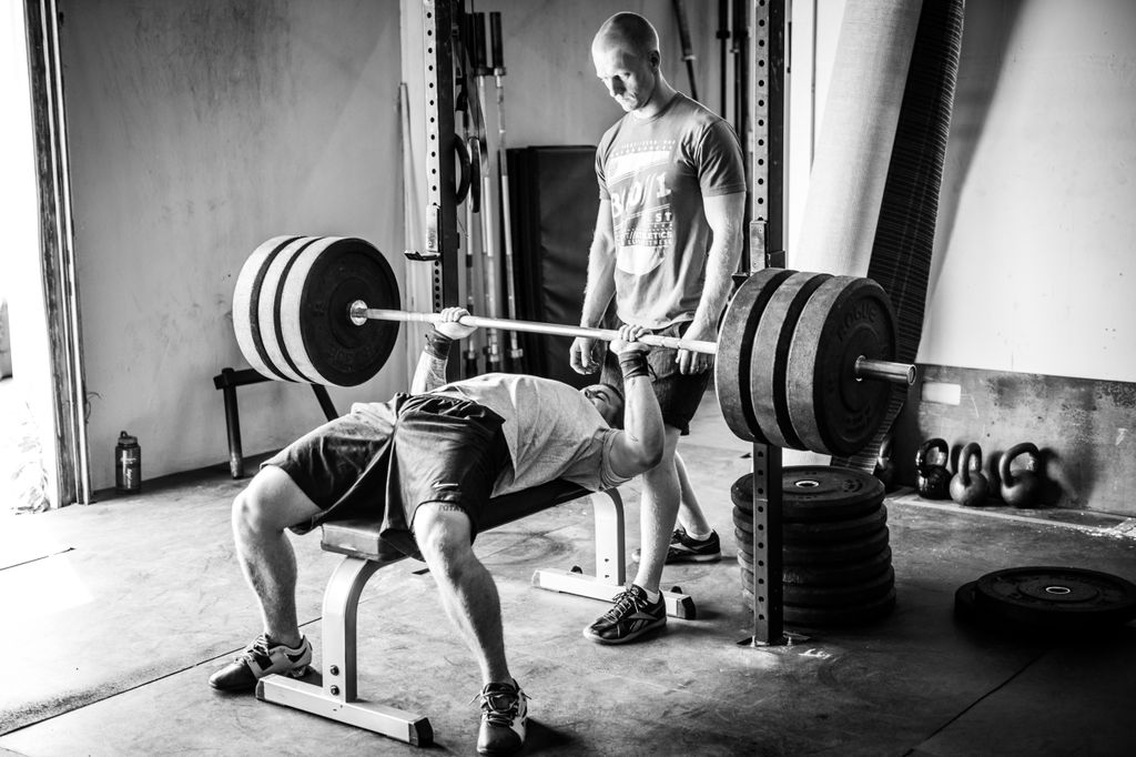 Matt, spotting a client with a heavy bench press.