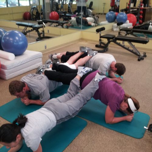 A few employees performing a stacked plank for exe
