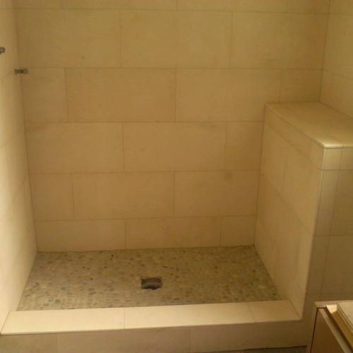 Limestone shower with river stone flooring. Very T