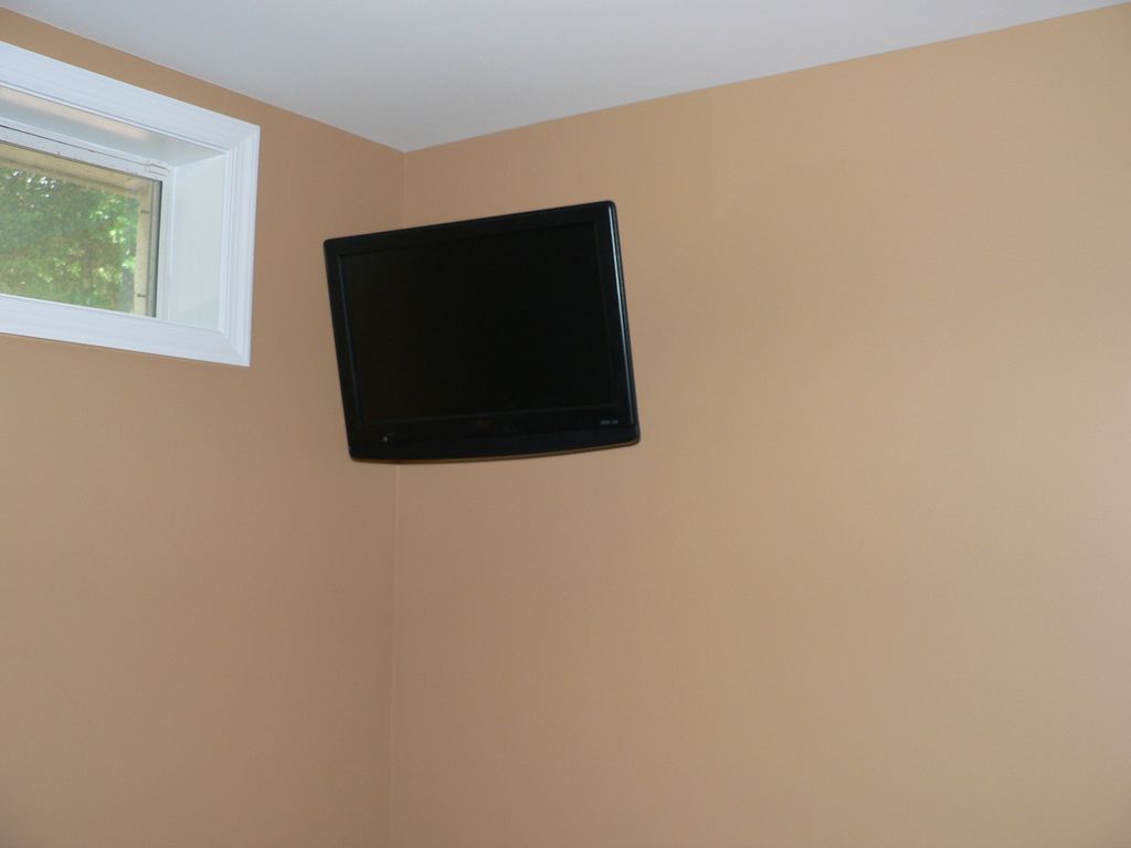 26" TV mounted in gym room.