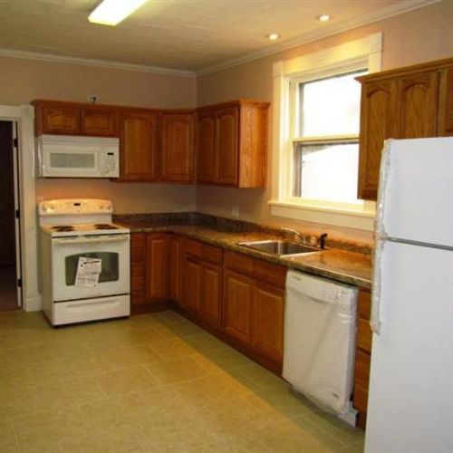 New kitchen with ceramic tile floor, cabinets, doo