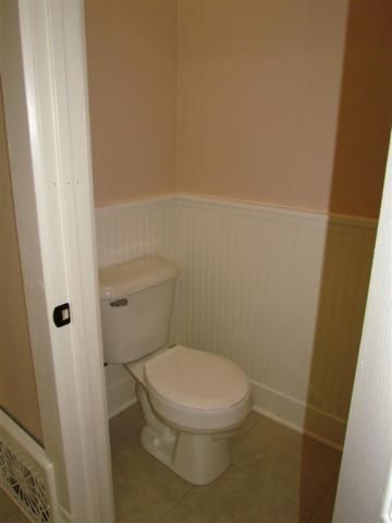 New bathroom with wainscot and ceramic tile.