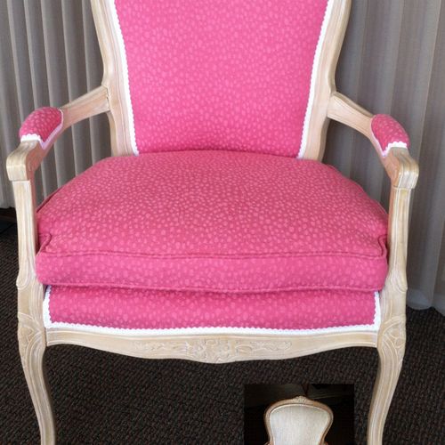 A cute French Provincial chair in pink and white.