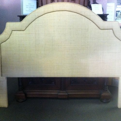 A headboard done in a linen fabric with nailhead t