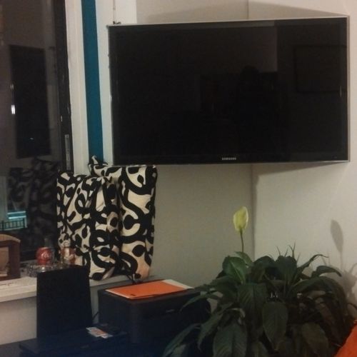 Flat screen TV installed in room corner with in-wa