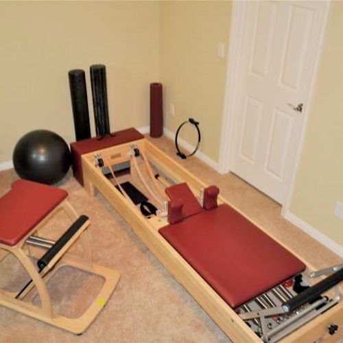 Pilates studio with reformer, chair, and props