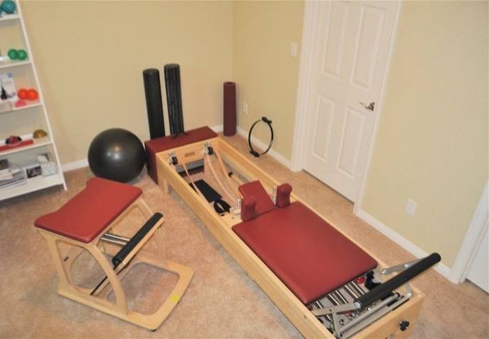 Pilates studio with reformer, chair, and props