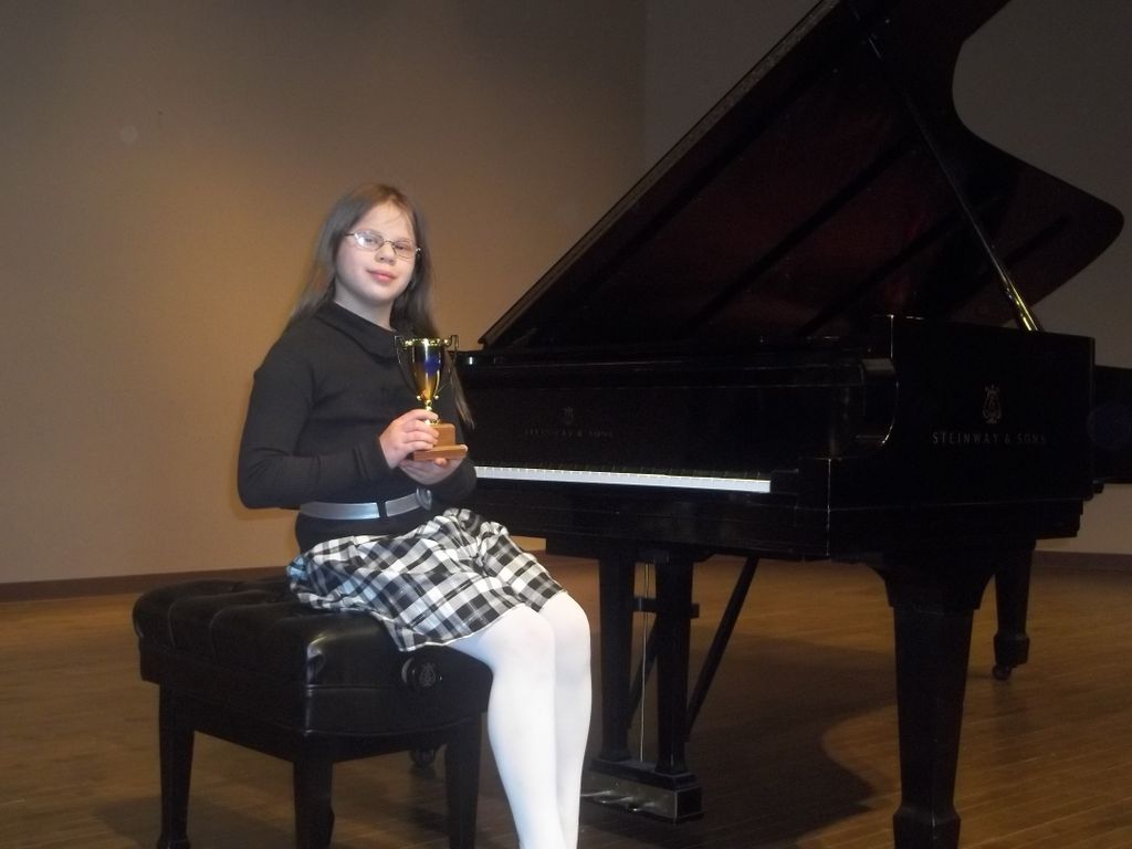 Elena winning a Gold Cup trophy for her piano play