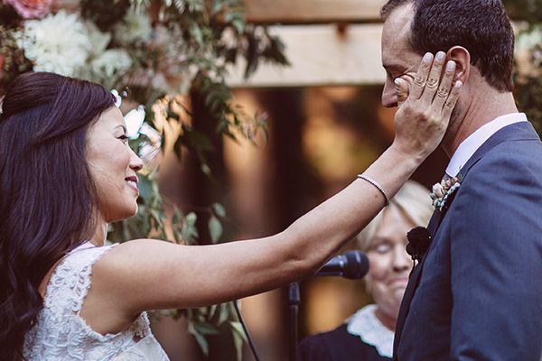 Bride wiping away her groom's tears during their w