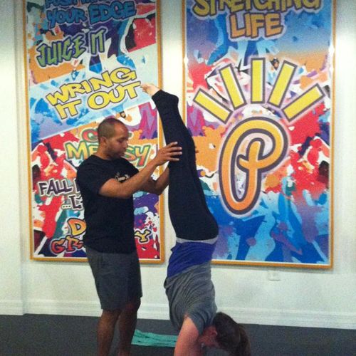 Assisting a student demonstrating handstand at the