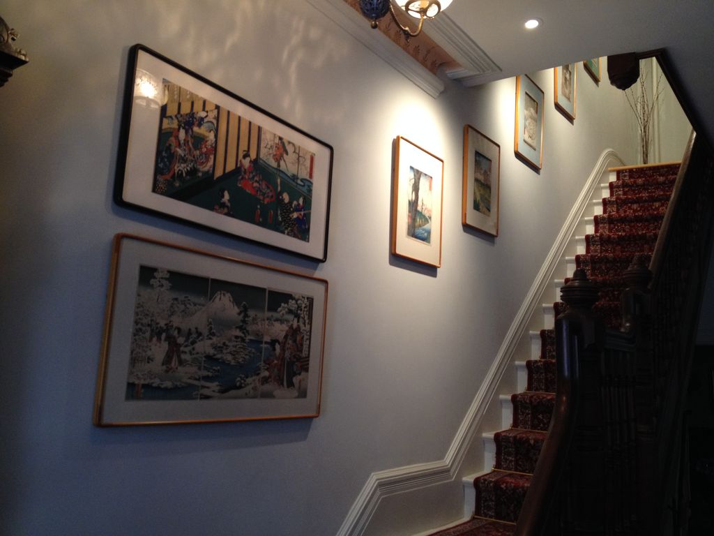 Oriental art hung over stairway.
