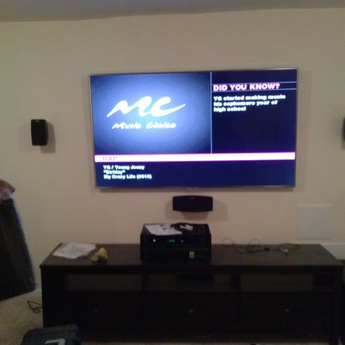 TV Mounted on wall with 5.1 Surround Sound.  Two s