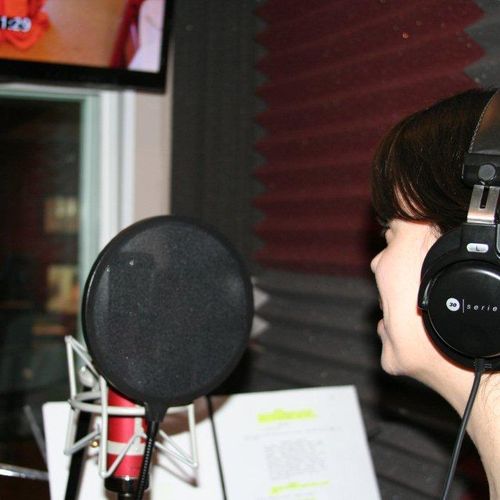 Actress in vocal booth recording ADR for a feature