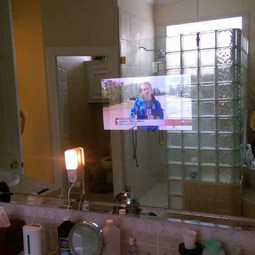 Flat screen mounted in the wall behind bathroom mi