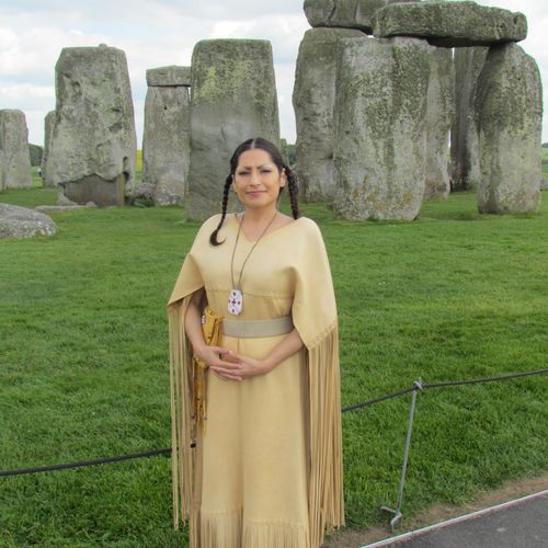 In full Native American regalia at Stonehenge, rea