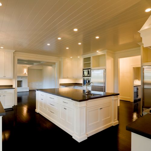 Very sleek kitchen with white cabinets and black c