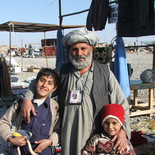 An Afghan father and his two children working at t