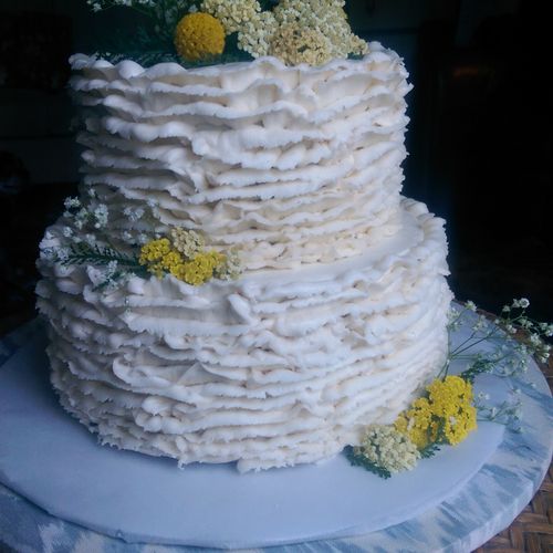 Two tiered buttercream cake with a trendy ruffle f