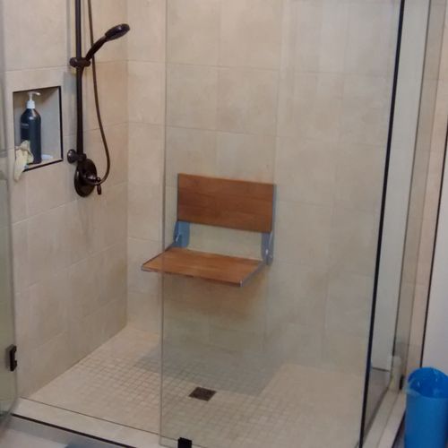 Handicap shower with low curb and fold down teak s
