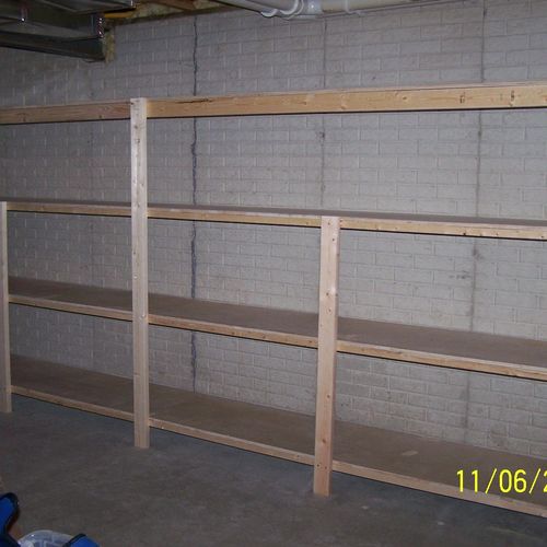 WOOD SHELVING  (attached to poured concrete wall. 