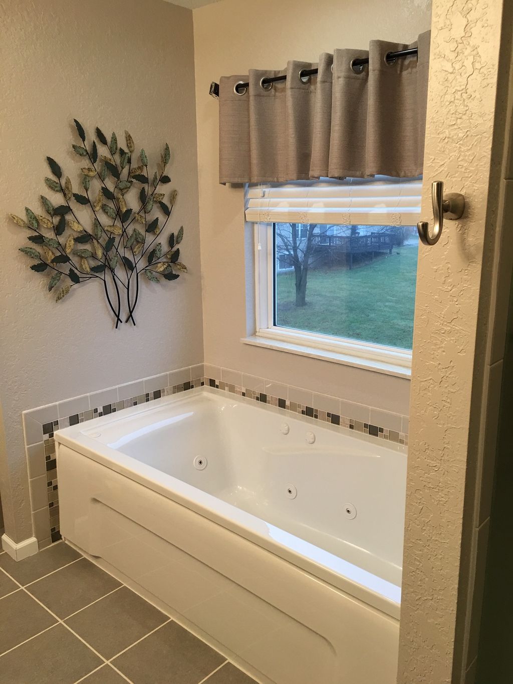 Jetted tub with tile accent.