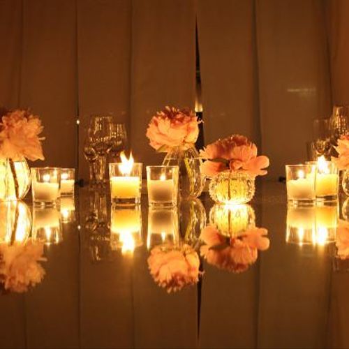 A simple peach carnation arrangement with candles 