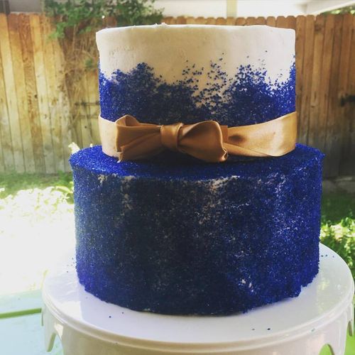 A sparkly navy cake tied together with a gold bow.