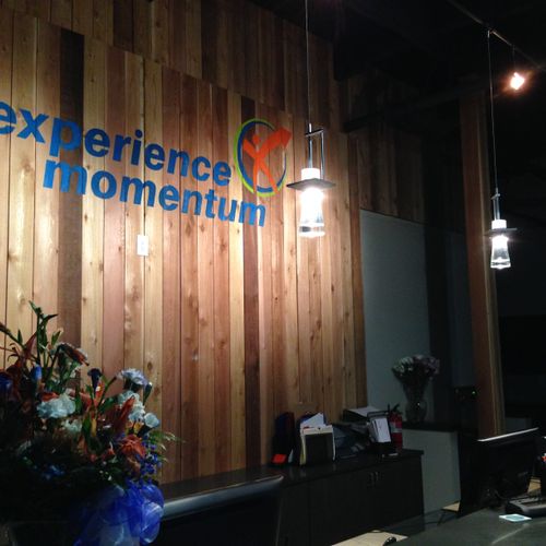 Experience Momentum hand painted logo sign behind 