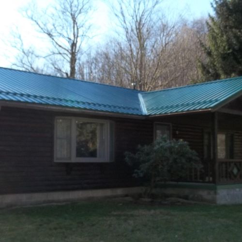 Installed metal roofing over shingles on log Home