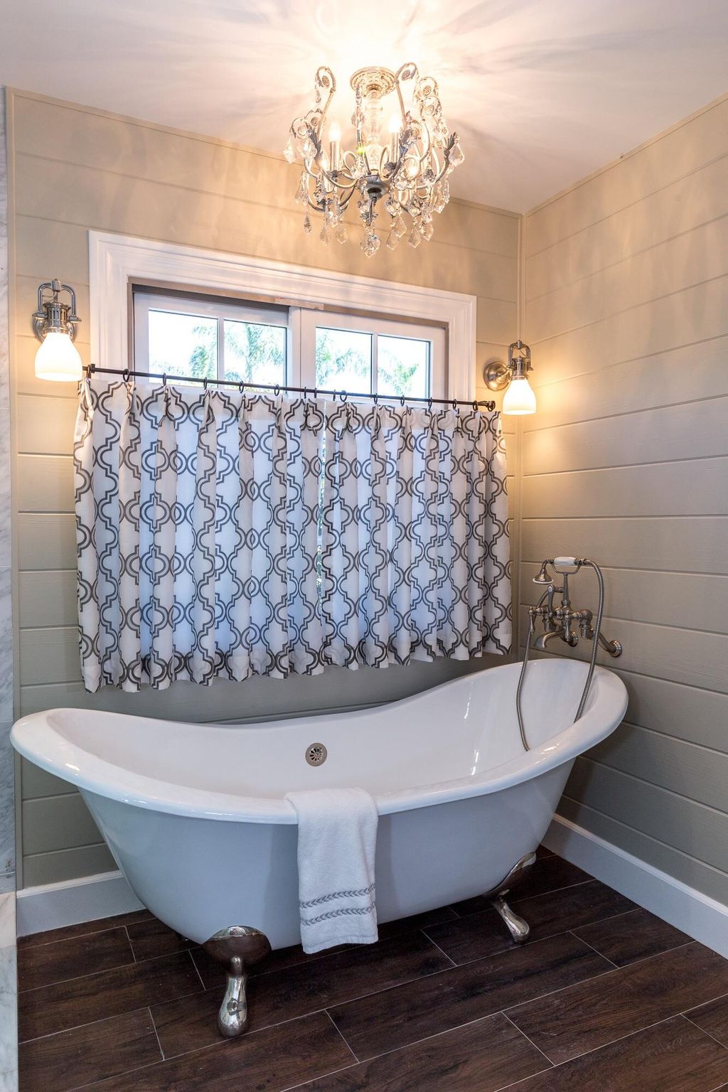 Claw-foot tub with cafe curtain, crystal chandelie