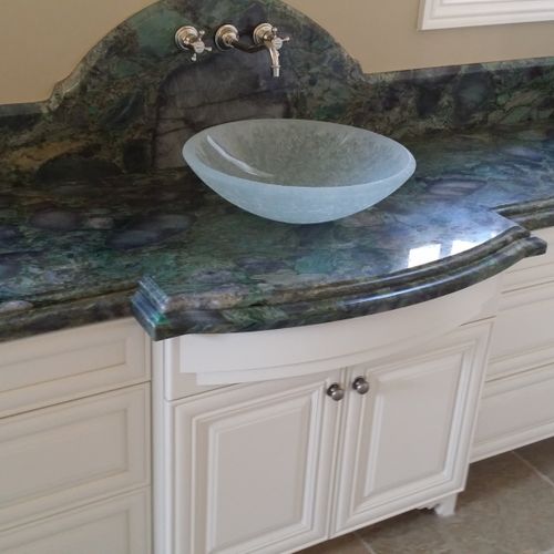 Bathroom granite counter with glass sink.