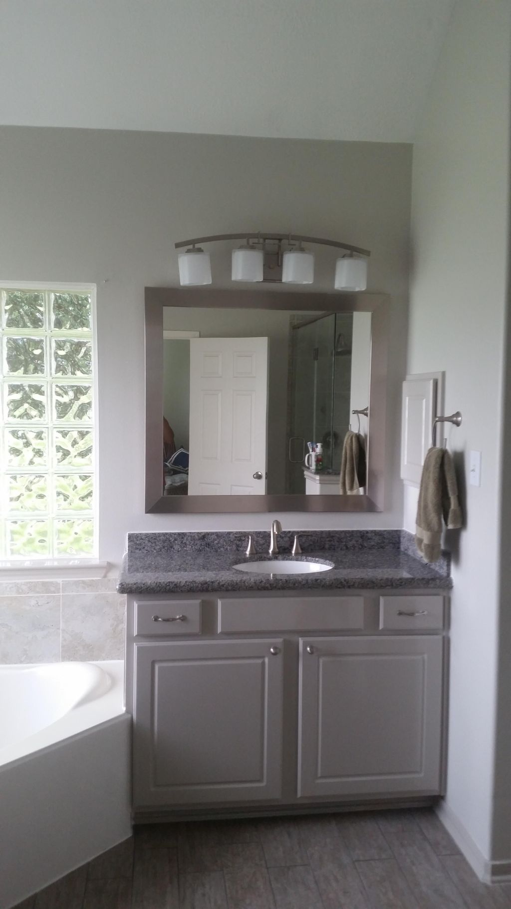Granite vanity top, framed mirror, and brush nicke