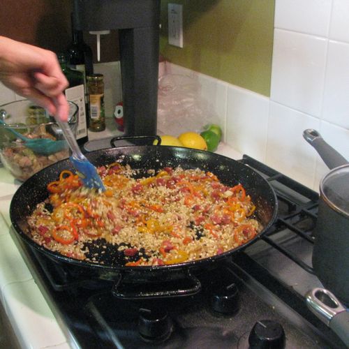 Adding rice to the Paella pan