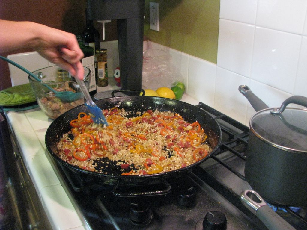 Adding rice to the Paella pan