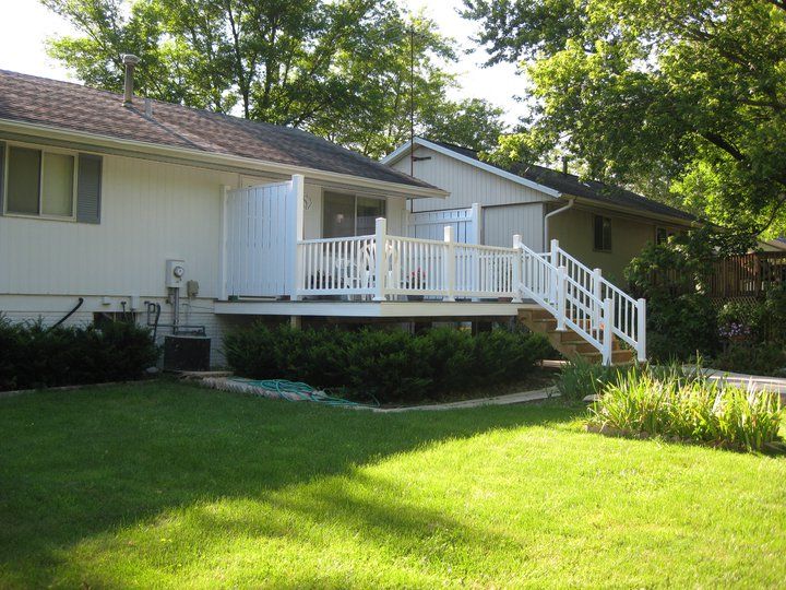 Vinyl deck with privacy fence, stairs, and railing