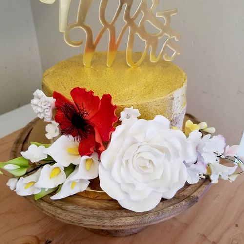 Semi-naked cake with a gold top/stripe and hand pa